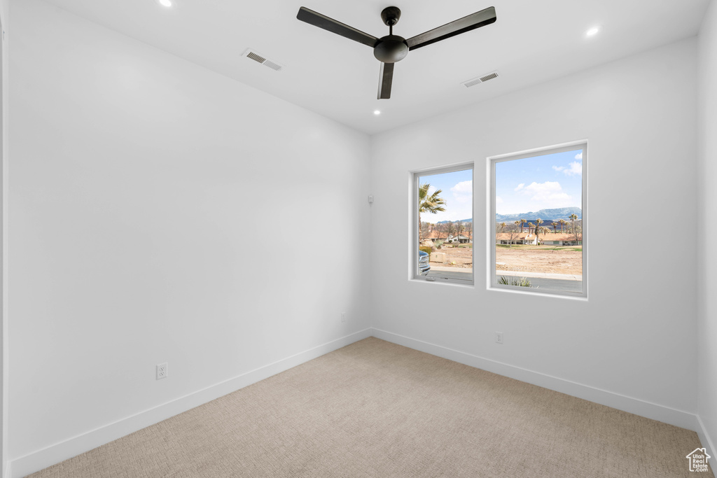 Carpeted empty room featuring a ceiling fan, baseboards, and recessed lighting