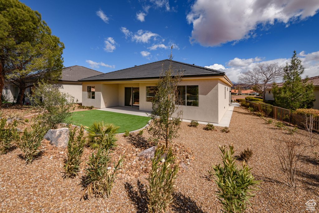 Rear view of property with stucco siding and a patio area