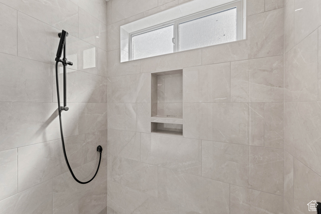Full bath featuring tiled shower