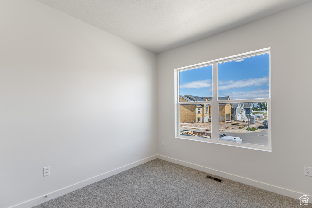 Unfurnished room with baseboards and carpet
