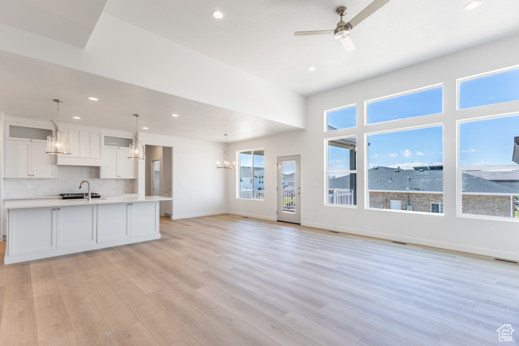 Kitchen featuring white cabinetry, light countertops, a chandelier, plenty of natural light, and recessed lighting