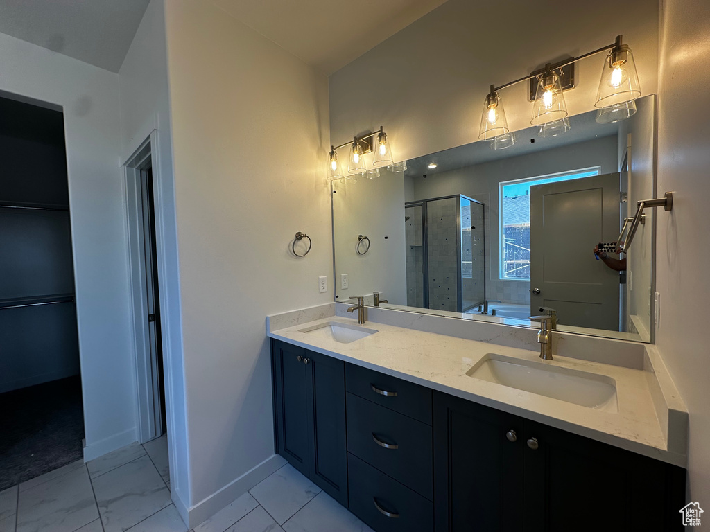 Full bath featuring a stall shower, double vanity, baseboards, marble finish flooring, and a bathtub