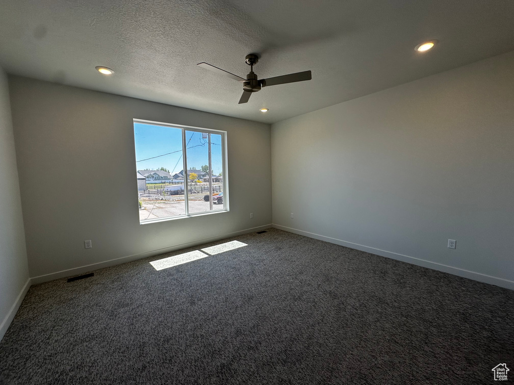 Carpeted spare room with ceiling fan, recessed lighting, baseboards, and a textured ceiling