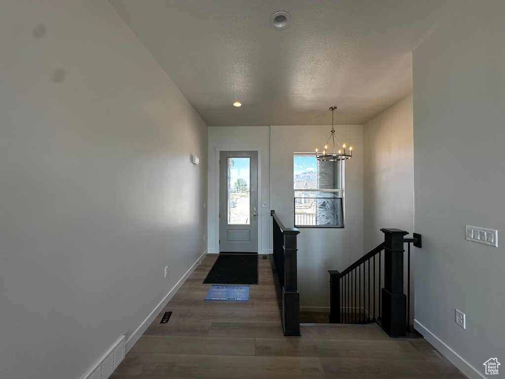 Entryway with a chandelier, wood finished floors, baseboards, and recessed lighting