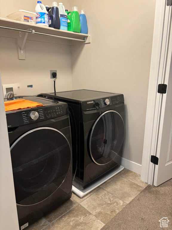 Clothes washing area with washer and dryer and baseboards