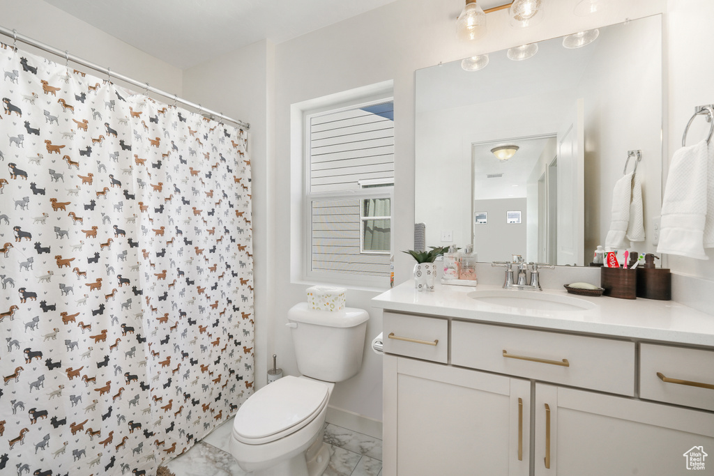Bathroom featuring marble finish floors, toilet, vanity, a shower with shower curtain, and baseboards