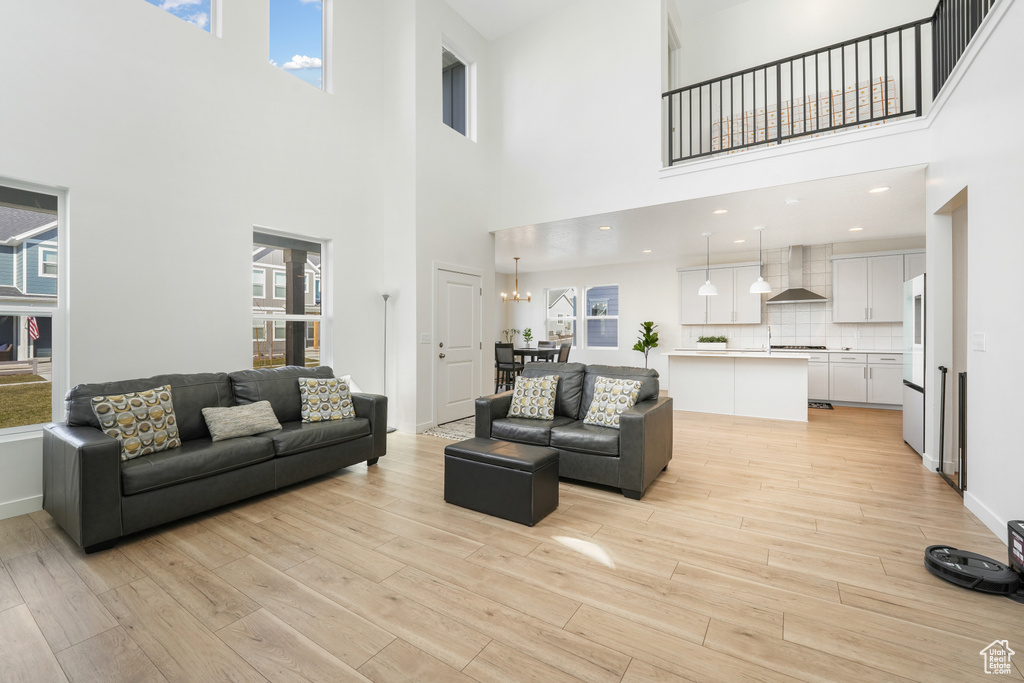 Living area with a towering ceiling, light wood-style floors, and baseboards