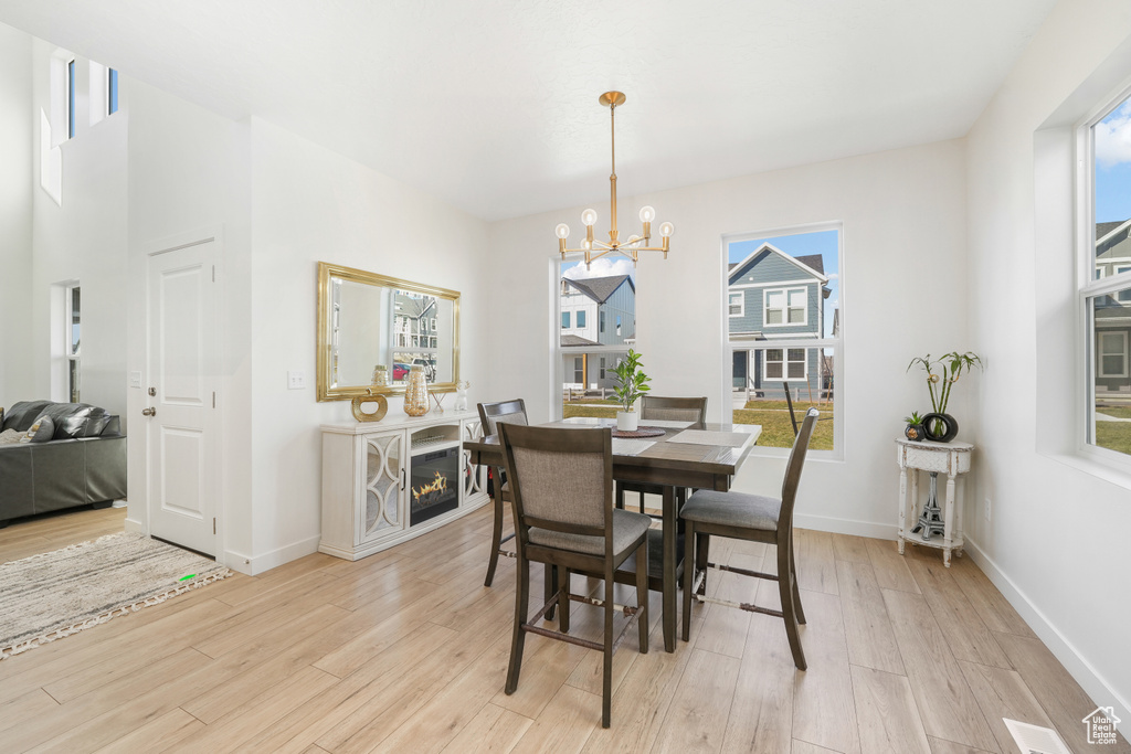 Dining area featuring a chandelier, healthy amount of natural light, and light wood-style flooring
