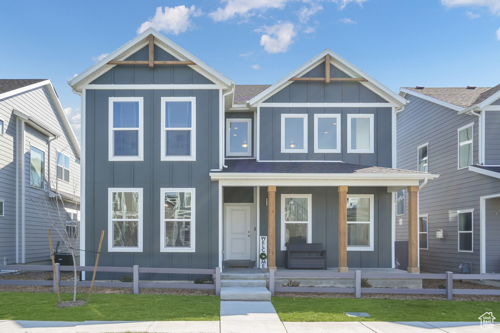 View of front facade featuring board and batten siding and covered porch