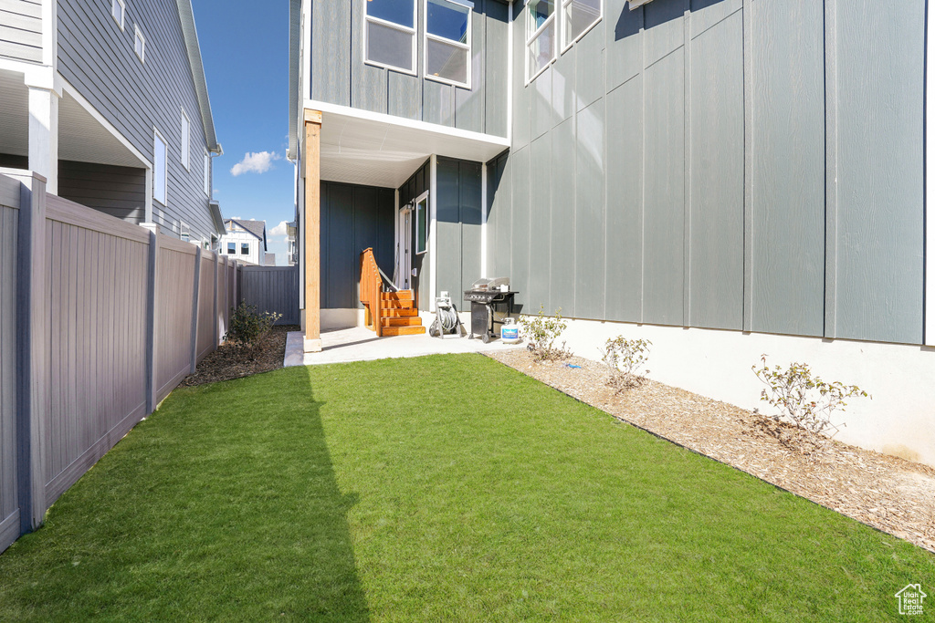 View of yard with entry steps and a patio