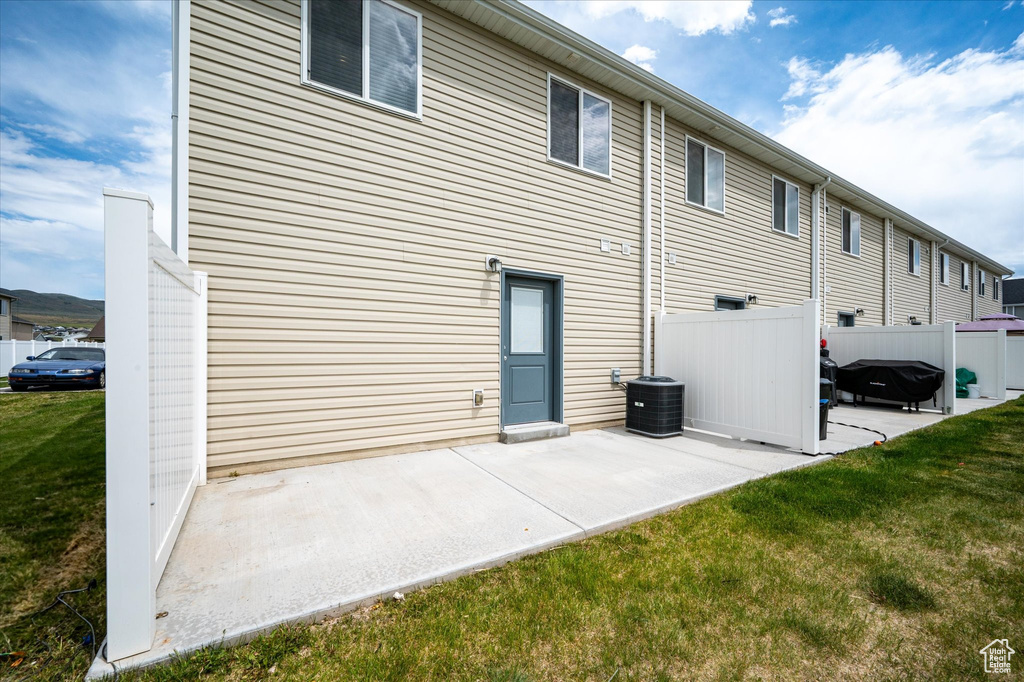 Rear view of property with a patio area and central air condition unit