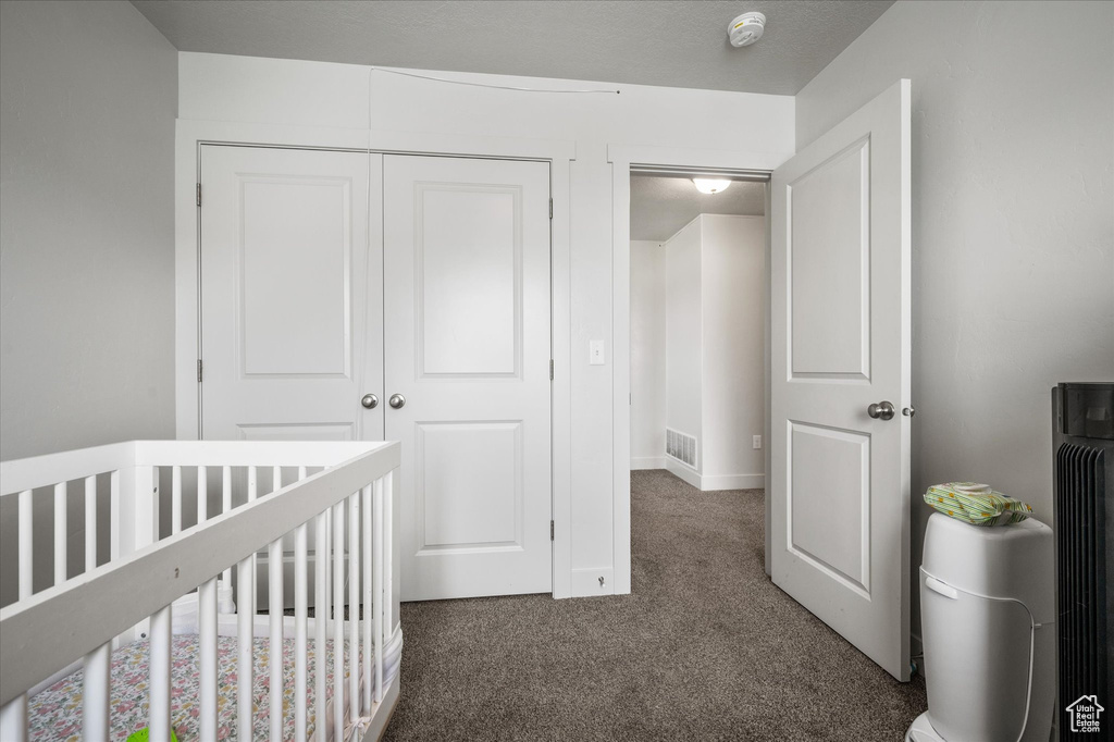 Bedroom with carpet, a closet, a nursery area, and baseboards