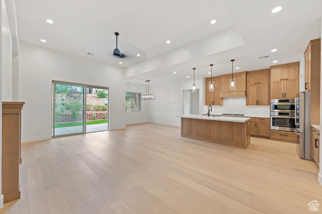 Kitchen featuring appliances with stainless steel finishes, recessed lighting, ceiling fan, a sink, and open floor plan