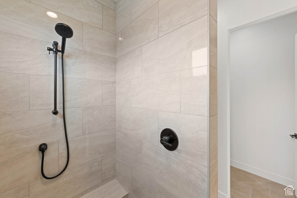 Full bathroom with tiled shower and baseboards