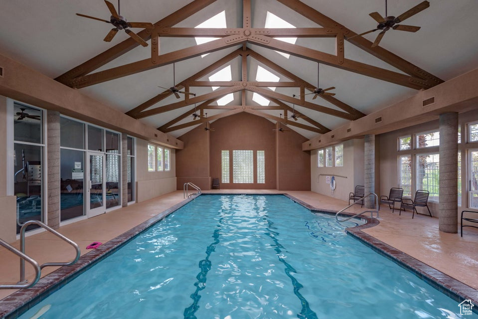 Indoor pool featuring a ceiling fan