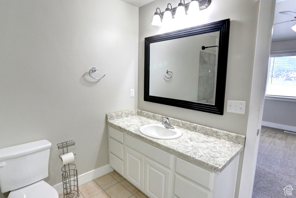 Full bath featuring baseboards, toilet, vanity, and tile patterned flooring