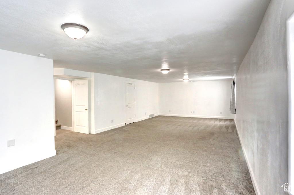 Finished basement with carpet flooring, stairs, and baseboards