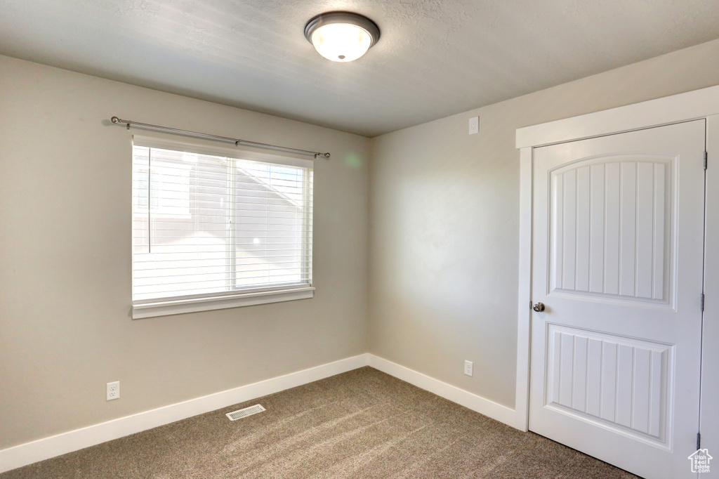 Spare room with baseboards and carpet flooring