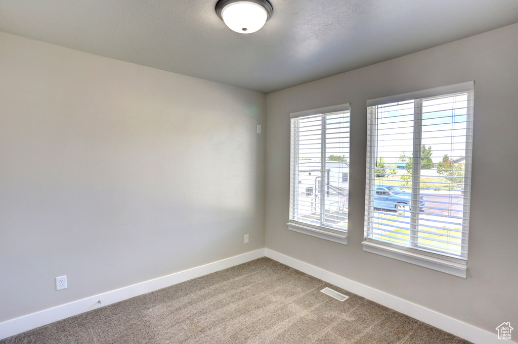 Carpeted spare room with baseboards