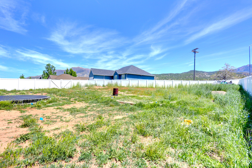 View of yard with fence and a mountain view