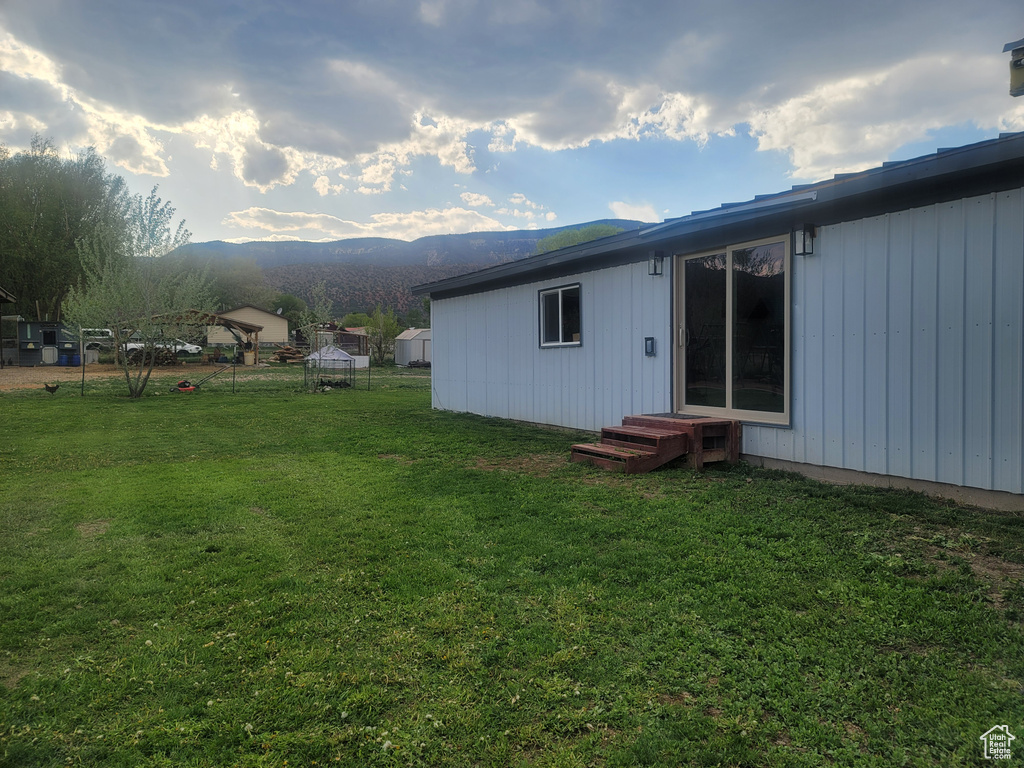 Back of property with a yard and a mountain view