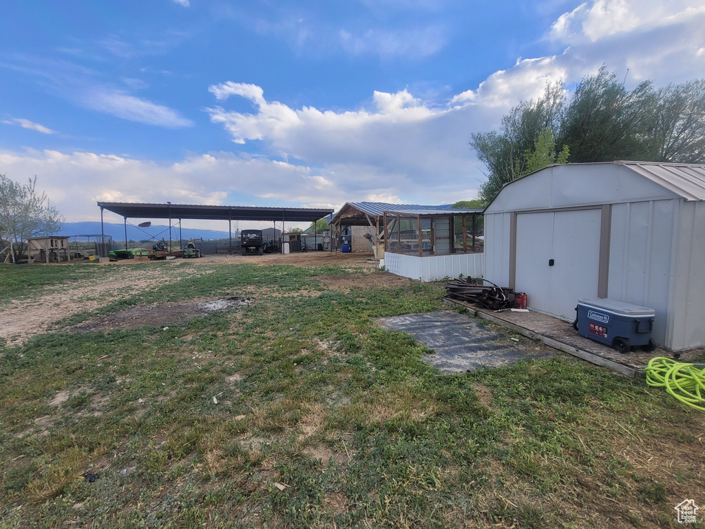 View of grassy yard with a shed and an outbuilding