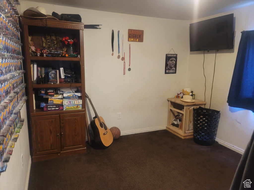 Misc room with dark carpet and baseboards