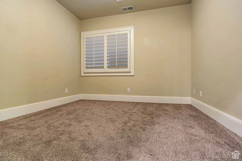 Empty room with carpet and baseboards