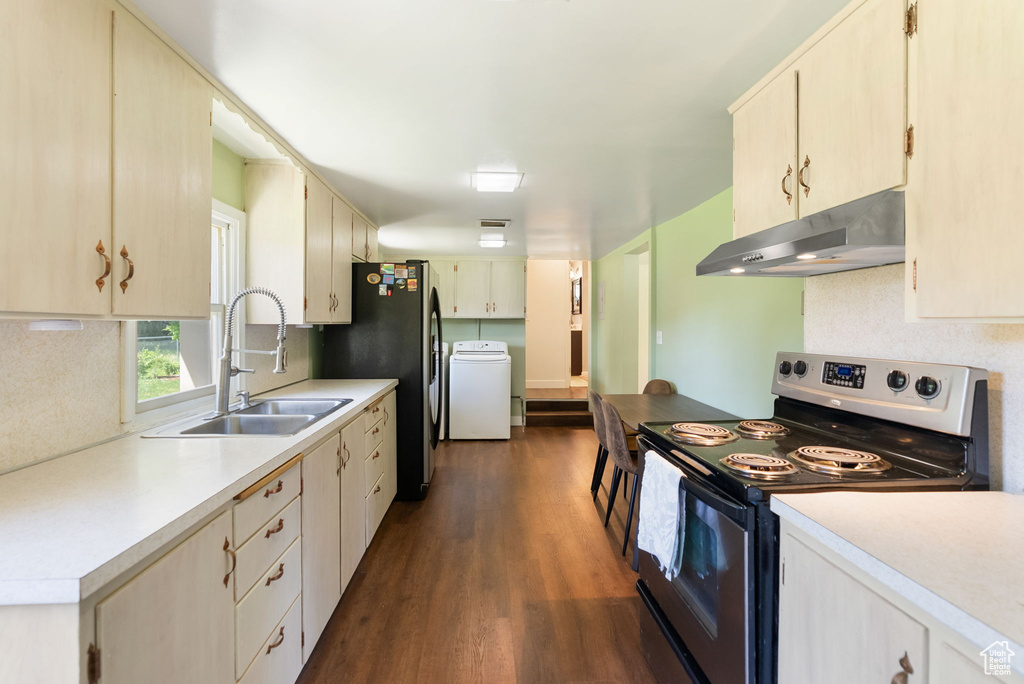 Kitchen featuring under cabinet range hood, stainless steel appliances, a sink, washer / clothes dryer, and dark wood-type flooring