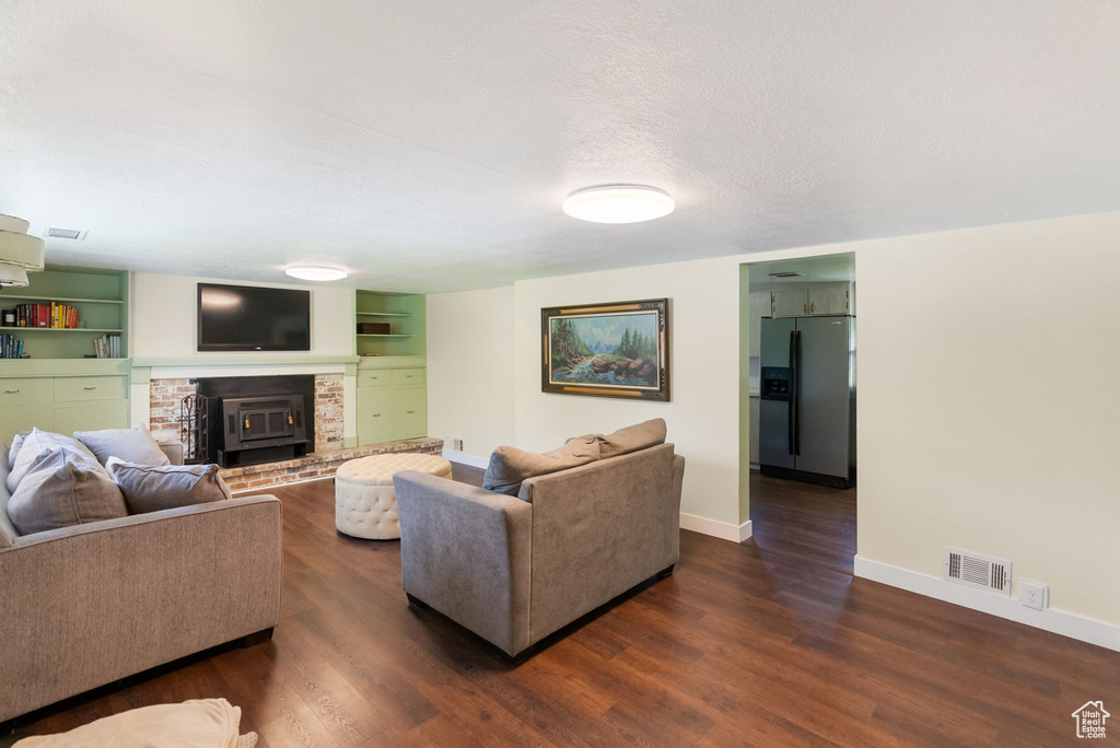 Living area with dark wood-style floors, baseboards, and a fireplace