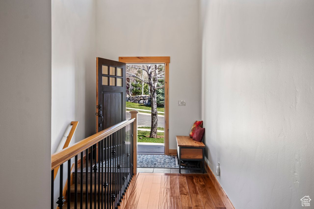 Entrance foyer with a high ceiling, baseboards, and wood finished floors