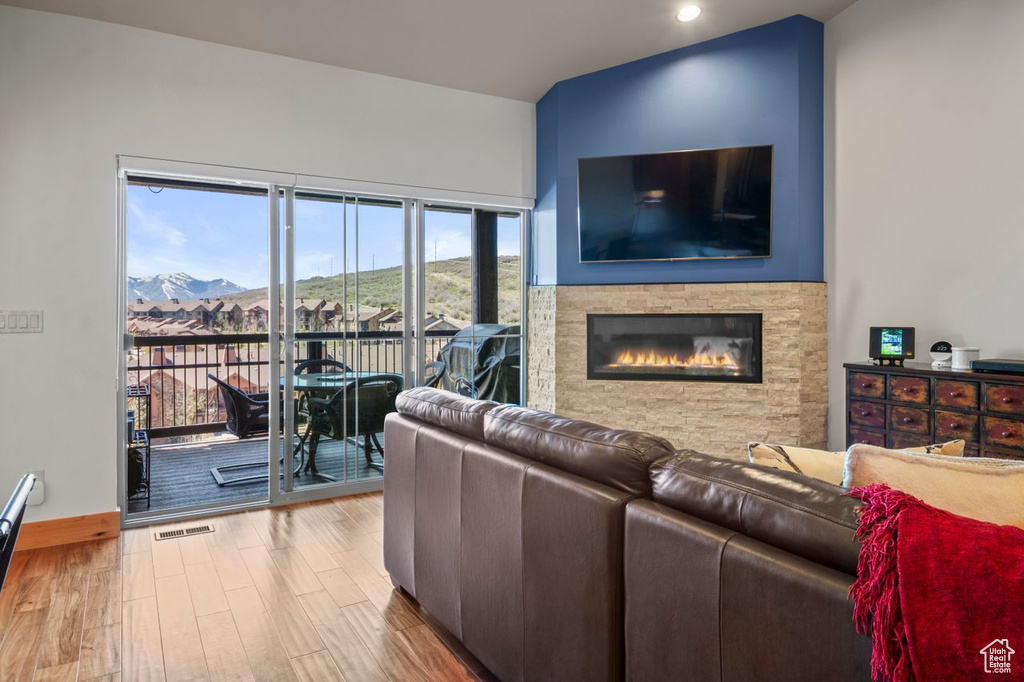 Living area with wood finished floors, visible vents, recessed lighting, a fireplace, and baseboards