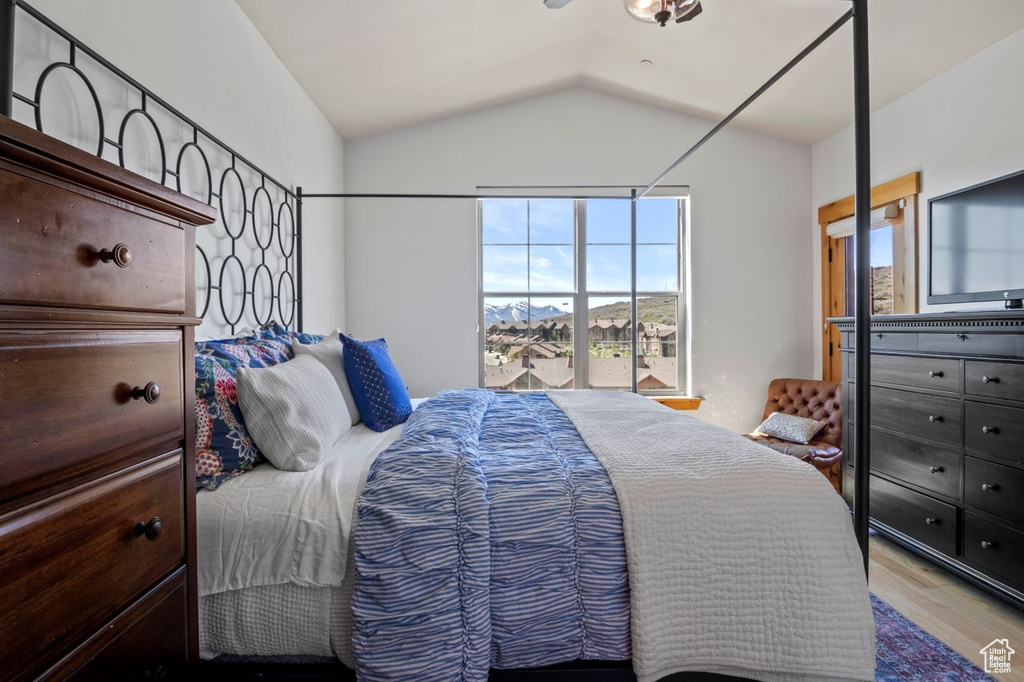 Bedroom featuring wood finished floors and lofted ceiling