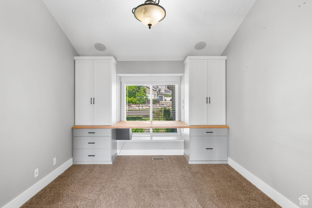 Unfurnished office featuring carpet floors and baseboards