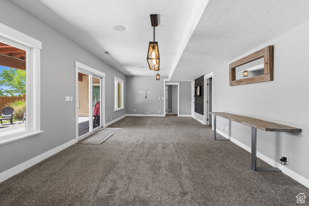 Carpeted empty room featuring plenty of natural light and baseboards
