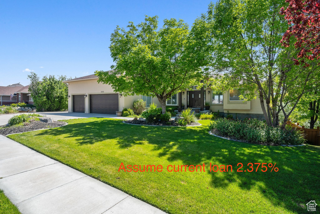 Obstructed view of property with stucco siding, a garage, and a front lawn