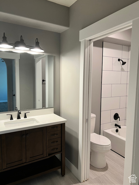 Bathroom featuring toilet, vanity, and shower / tub combination