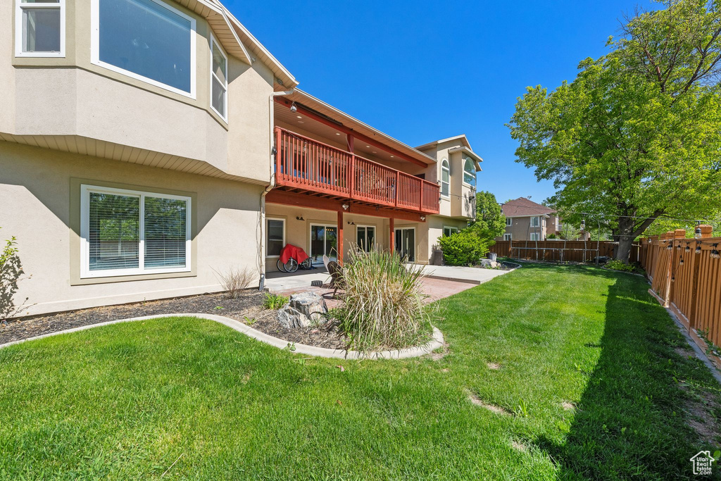 Rear view of house with stucco siding and a patio area