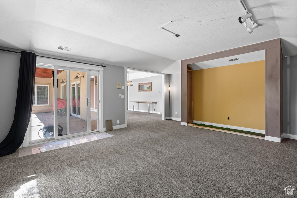Carpeted empty room with track lighting and baseboards