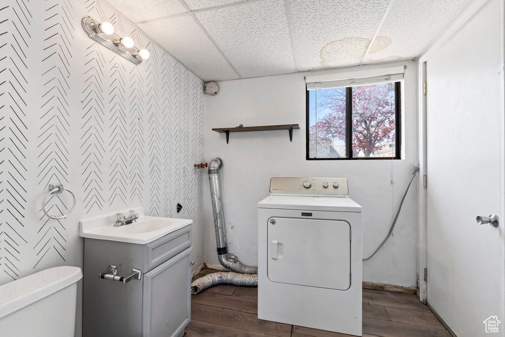 Laundry room with washer / clothes dryer, dark wood-style flooring, and an accent wall
