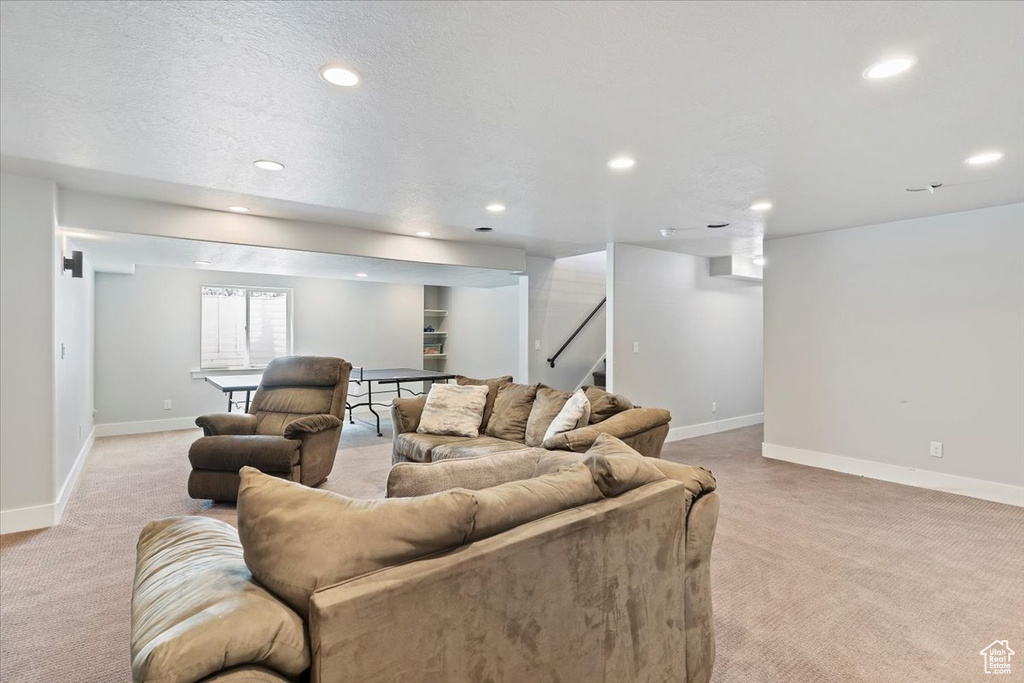 Living area with light carpet, recessed lighting, and baseboards