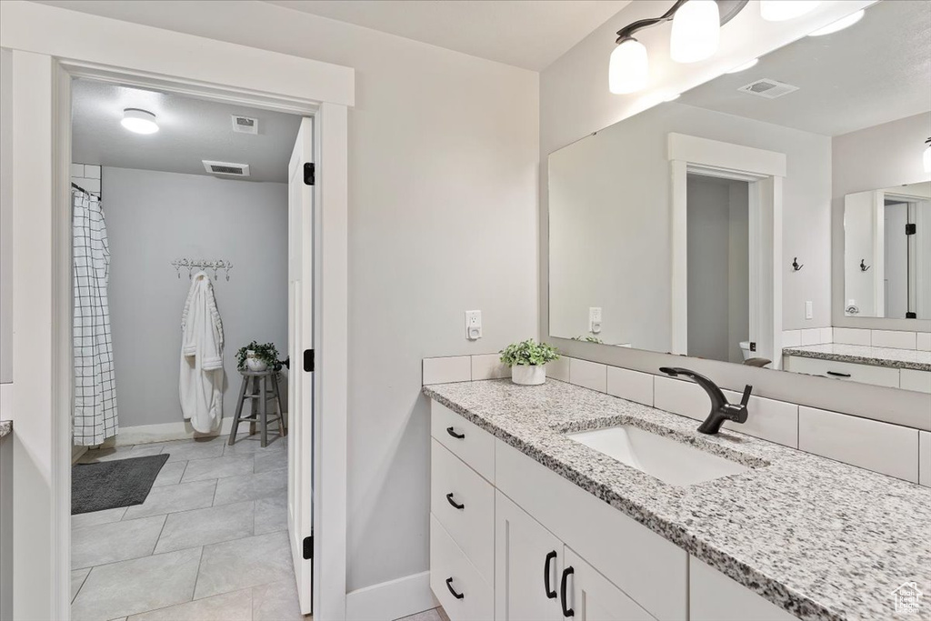 Bathroom featuring baseboards, vanity, and tile patterned floors