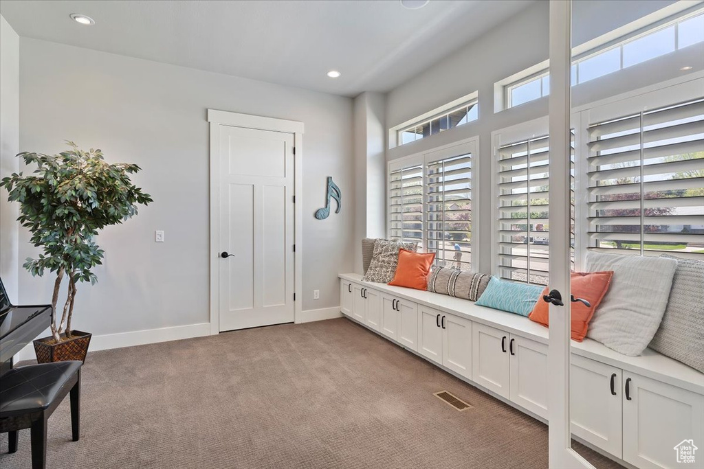 Living area with light carpet, baseboards, and recessed lighting