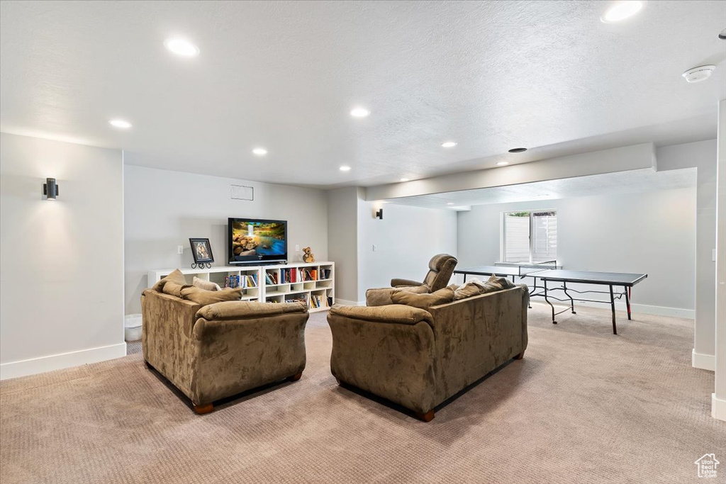 Living room with light colored carpet, recessed lighting, and baseboards