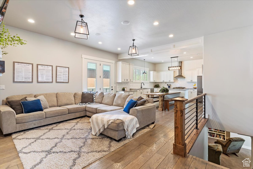 Living area with light wood-style flooring and recessed lighting