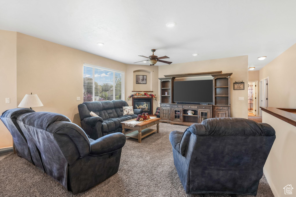 Living area featuring carpet floors, a ceiling fan, recessed lighting, and a glass covered fireplace