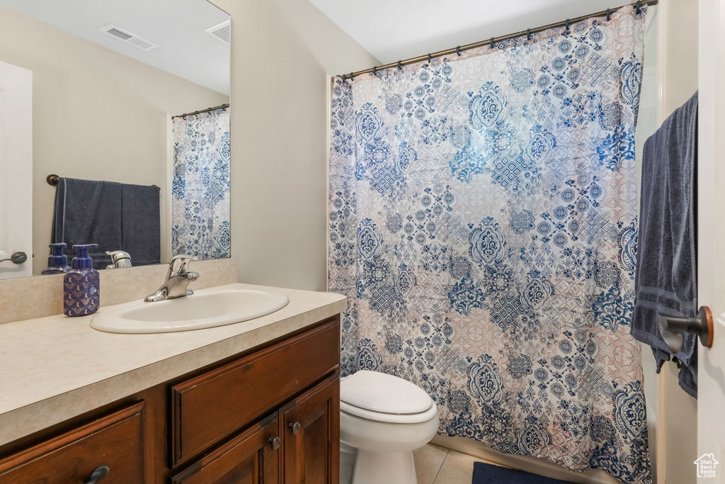 Full bath with tile patterned flooring, toilet, vanity, and curtained shower