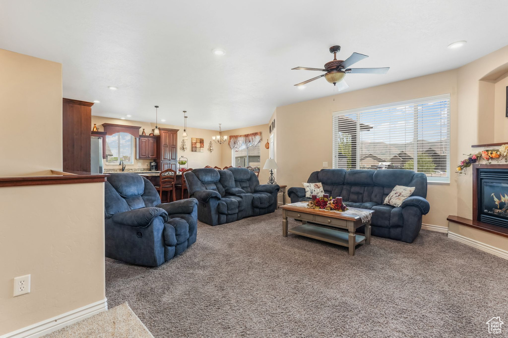 Living area featuring carpet flooring, ceiling fan, a glass covered fireplace, recessed lighting, and baseboards