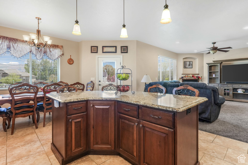Kitchen with light tile patterned flooring, a chandelier, ceiling fan, and pendant lighting