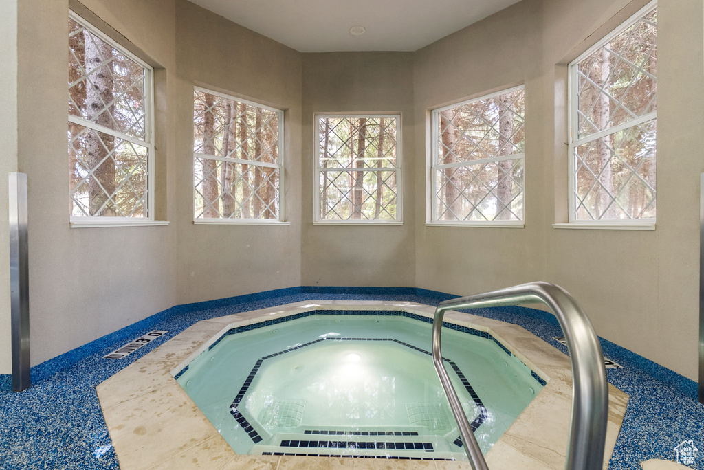 View of swimming pool featuring a hot tub
